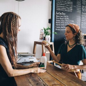 Two women interacting in an eco-friendly store, promoting organic products and sustainability.